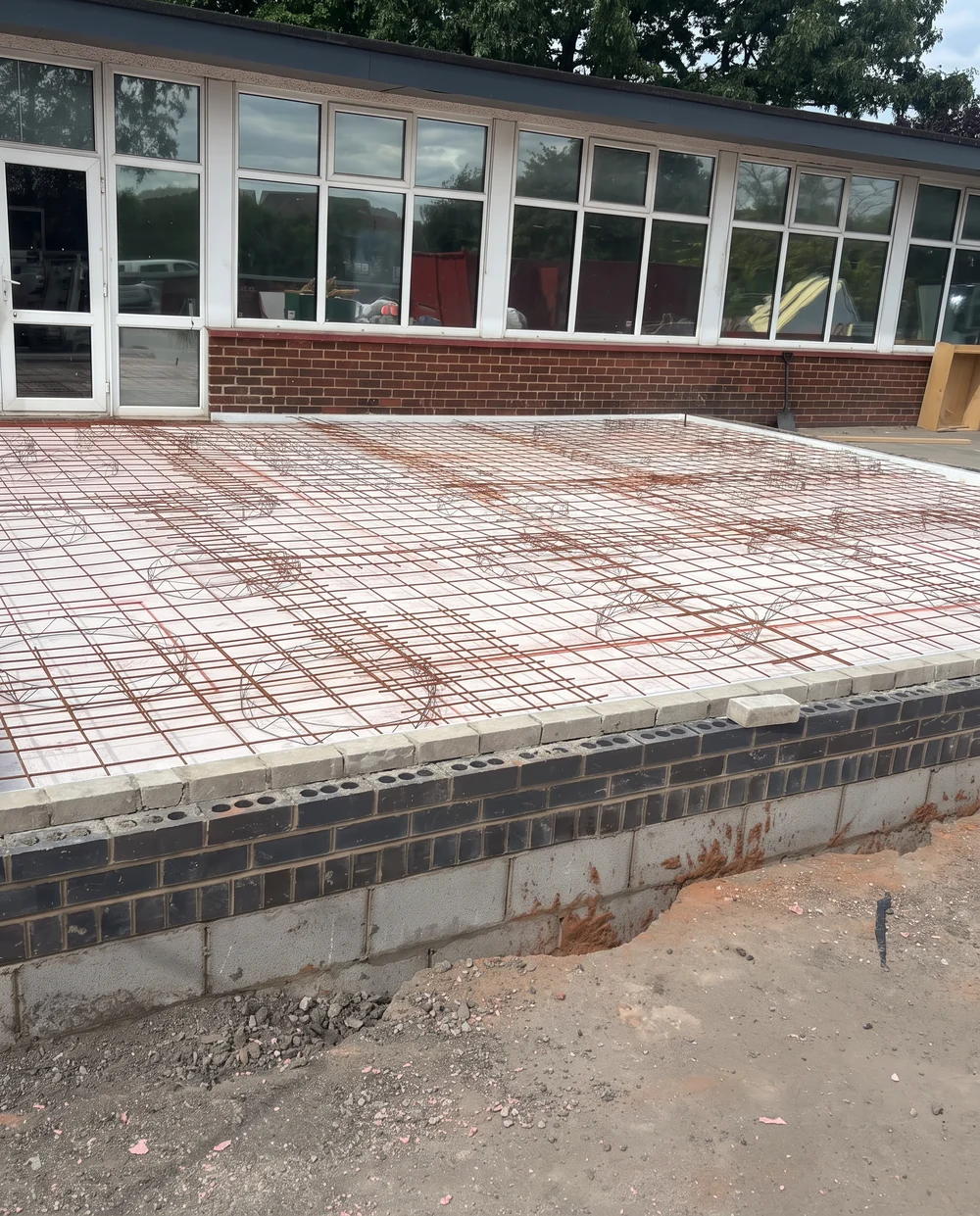 Steel reinforcement mesh and cages laid over a new slab base before the concrete pour, commercial groundworks by DVH Innovations in Greater Manchester